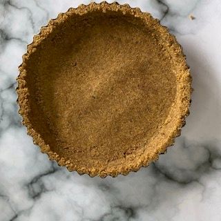 Una crosta di torta è appoggiata su una superficie di marmo.