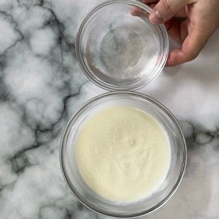 Una persona tiene due ciotole di cibo su un tavolo.