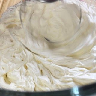 Primo piano di un mixer in una ciotola di panna montata.