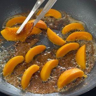 Le pesche vengono cotte in padella con un cucchiaio