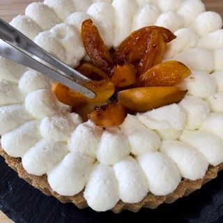 Una torta con panna montata e pesche sopra