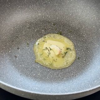 Un pezzo di burro si scioglie in una padella.