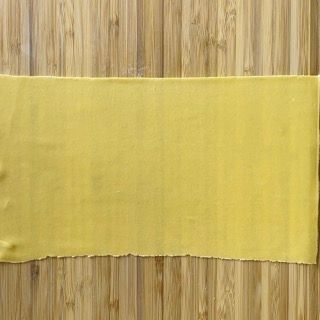 Un pezzo di carta gialla è appoggiato su un tavolo di legno.