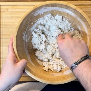 Una persona sta mescolando qualcosa in una ciotola di legno