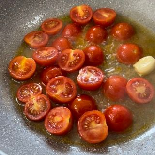 Pomodori e aglio vengono cotti in una padella