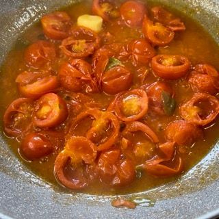 Una padella piena di pomodori e altre verdure