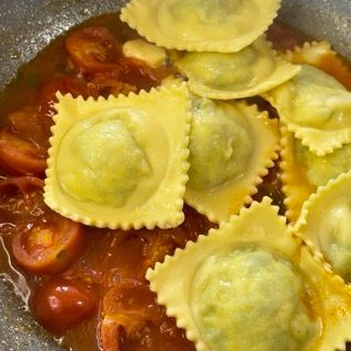 Una padella piena di ravioli e salsa di pomodoro