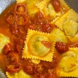 Un primo piano di ravioli e salsa di pomodoro in una padella