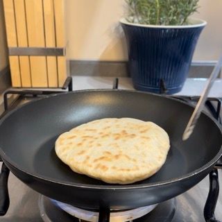 Un pane pita viene cotto in una padella