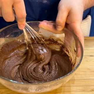 Una persona sta sbattendo una ciotola di impasto al cioccolato