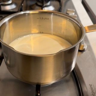 Una pentola di acciaio inossidabile piena di liquido bianco su un fornello