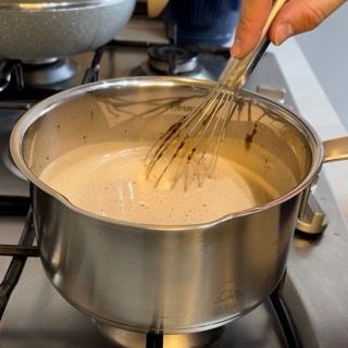 Una persona sta sbattendo qualcosa in una pentola sul fornello