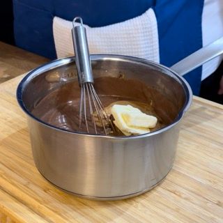 Una pentola di salsa al cioccolato con una frusta e del burro dentro