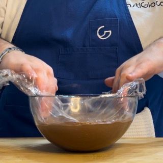 Una persona che indossa un grembiule con la lettera g sopra