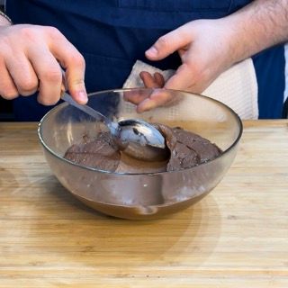 Una persona sta mescolando il cioccolato in una ciotola con un cucchiaio