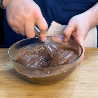 Una persona sta mescolando qualcosa in una ciotola con una frusta