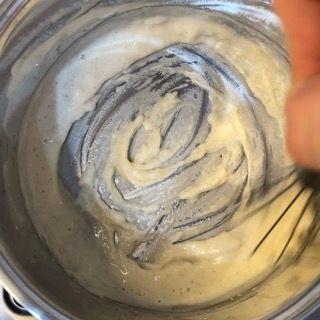 Una persona sta mescolando qualcosa in una ciotola con una frusta