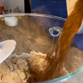 Una persona sta versando il caffè in una ciotola di vetro