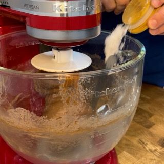 Una persona sta versando del liquido in un mixer KitchenAid