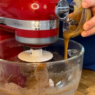 Una persona sta versando del liquido in un mixer KitchenAid