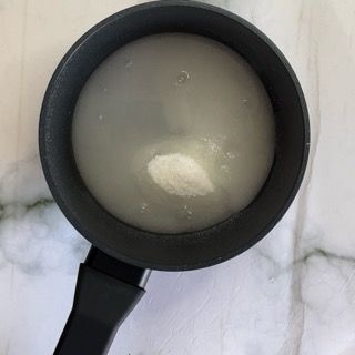 Su un tavolo c'è una pentola piena di liquido bianco.