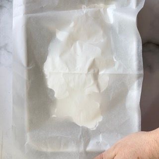 Una persona tiene in mano un pezzo di carta oleata.