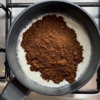 Una pentola piena di latte e cacao in polvere sul fornello