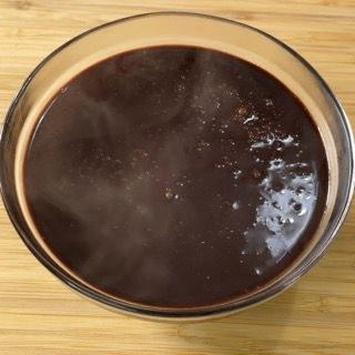Una ciotola di salsa al cioccolato su un tavolo di legno
