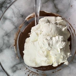 La panna montata viene versata in una ciotola di cioccolato