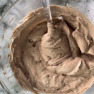 Una ciotola di glassa al cioccolato con un cucchiaio dentro