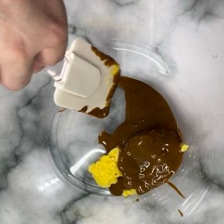 Una persona versa la salsa in una ciotola con una spatola