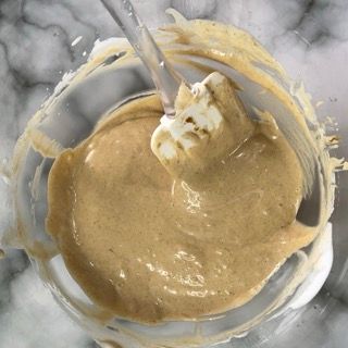 Una ciotola di liquido marrone con un cucchiaio dentro