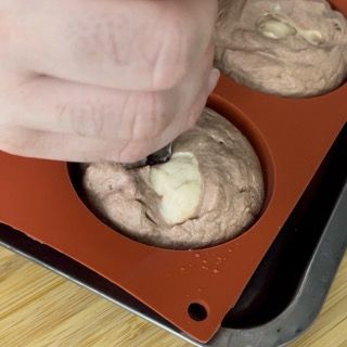 Una persona versa l'impasto in uno stampo per muffin in silicone