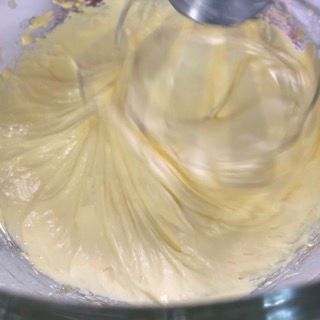 Primo piano di un mixer che mescola un liquido giallo in una ciotola.