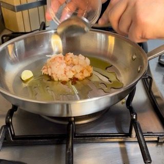 Una persona sta versando l'olio in una padella sul fornello