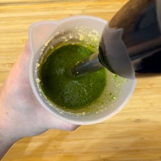 Una persona versa del liquido verde in un misurino.