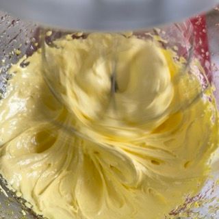 Un primo piano di un frullatore pieno di glassa gialla