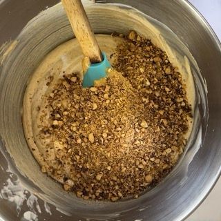Una ciotola di pastella con noci e una spatola dentro