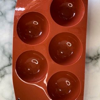 Un vassoio rosso con sei buchi