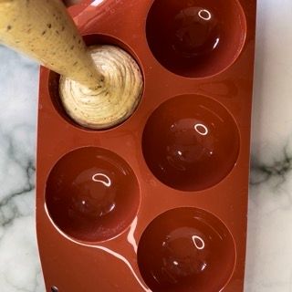 Una persona sta versando qualcosa in un vassoio di silicone rosso