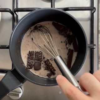 Una persona sta mescolando il cioccolato in una pentola di latte