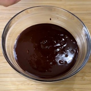 Una ciotola di salsa al cioccolato su un tavolo di legno