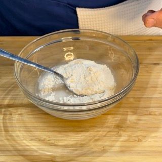 Una ciotola di farina con un cucchiaio dentro