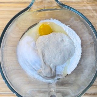 Un misurino di vetro pieno di farina, uova e liquido.