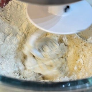 Una persona sta mescolando gli ingredienti in una ciotola con un mixer.