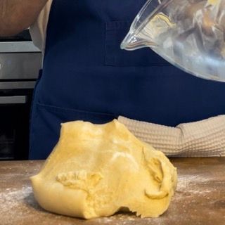 Una persona sta versando del liquido in una ciotola di pasta