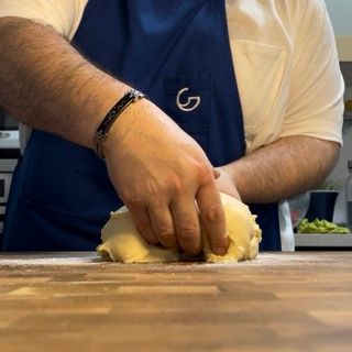 Una persona che indossa un grembiule blu con la lettera g sopra