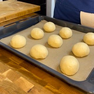 Una teglia di palline di pasta su un pezzo di carta oleata