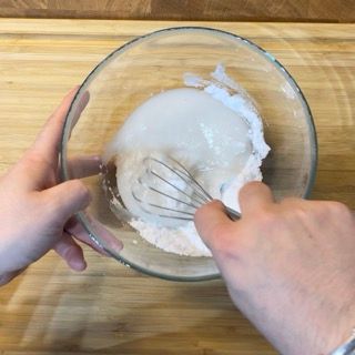 Una persona sta mescolando qualcosa in una ciotola con una frusta