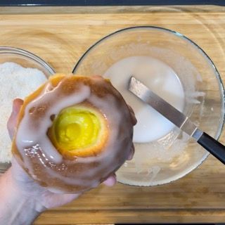 Una persona tiene in mano una ciambella glassata